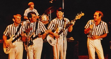 An image of the Beach Boys in blue striped shirts performing on stage as Musical Influences and Inspirations.