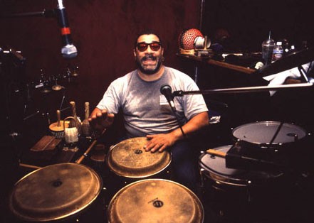 An image of Lenny Castro playing three congas.