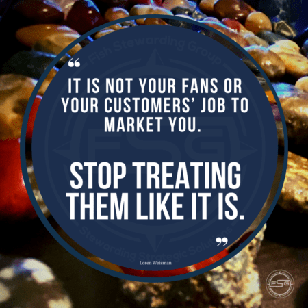 A text quote over some shiny rocks on a dark background that reads "it is not your fans or your customers job to market you. Stop treating them like it is."