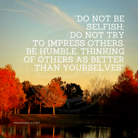 A quote graphic with a background of orange and dark green trees at sunset with a small pond in front with a clear sky above with one whispy cloud. In center is an FSG logo watermark and a quote in white text that is credited to Philippians 2:3 NLT in a small font on the bottom and in the upper right center the quote reads, ““Do not be selfish; do not try to impress others. Be humble, thinking of others as better than yourselves.”