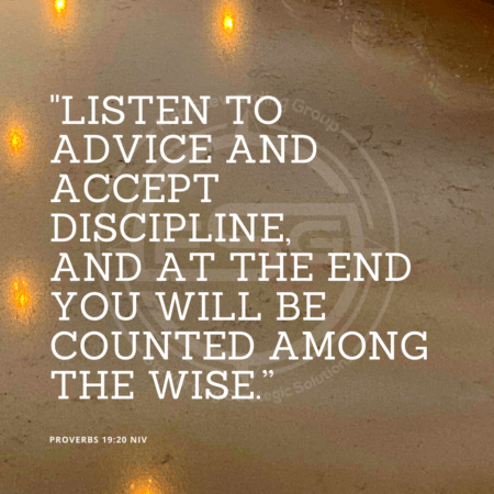 A quote graphic with a background of a wall and a marble counter top with some lights reflecting on it. In center is an FSG logo watermark and a quote in white text that is credited to Proverbs 19:20 NIV in a small font on the bottom left and in the upper right center the quote reads, "Listen to advice and accept discipline, and at the end you will be counted among the wise.”