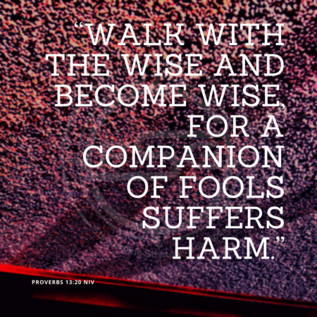 A quote graphic with a background of light red and purple dots with a red line on the bottom. In center is an FSG logo watermark and a quote in white text that is credited to Proverbs 13:20 NIV in a small font on the bottom left and in the upper right center the quote reads, “Walk with the wise and become wise, for a companion of fools suffers harm.” From the strategic messaging and optics quotes blog.